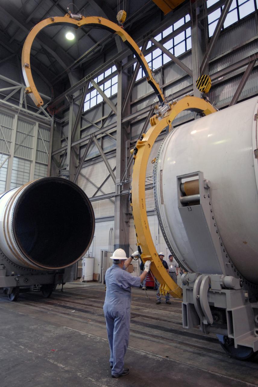 CAPE CANAVERAL, Fla. -- In Hangar AF at Cape Canaveral, Fla., workers remove the separation rings from around a segment of one of the retrieved solid rocket boosters from the STS-126 launch. The pins attaching the segments to each other are removed at the start. Each separation ring has three joints that help mold the ring around the segment and an air motor is used to rotate the rings to separate the segments. After disassembly, the segments will be sent to ATK (Alliant Techsystems) in Utah for final processing and return to Kennedy for another shuttle launch. Photo credit: NASA/Jack Pfaller