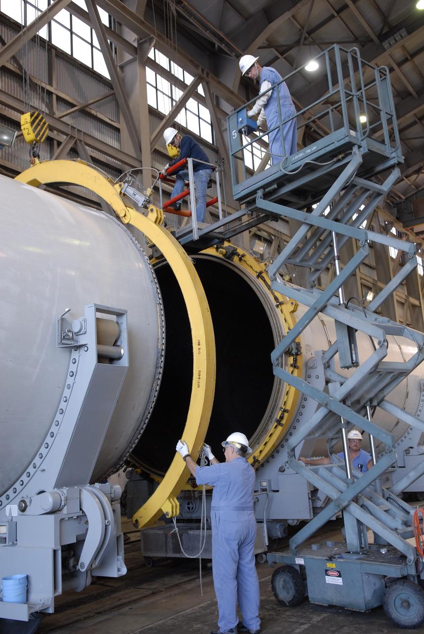 CAPE CANAVERAL, Fla. -- In Hangar AF at Cape Canaveral, Fla., workers again remove separation rings from around segments of one of the retrieved solid rocket boosters from the STS-126 launch. The pins attaching the segments to each other are removed at the start. Each separation ring has three joints that help mold the ring around the segment and an air motor is used to rotate the rings to separate the segments. After disassembly, the segments will be sent to ATK (Alliant Techsystems) in Utah for final processing and return to Kennedy for another shuttle launch. Photo credit: NASA/Jack Pfaller