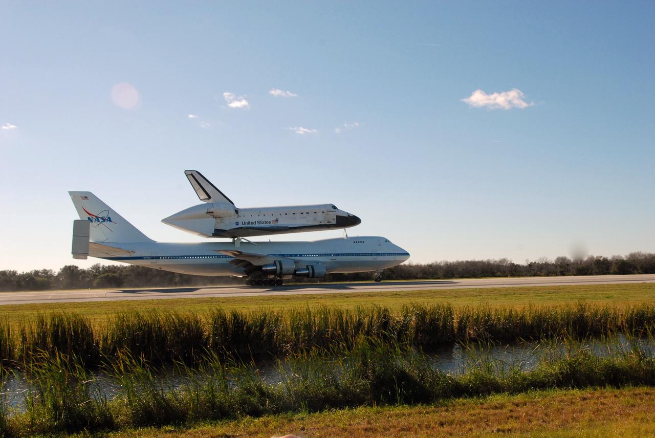 CAPE CANAVERAL, Fla. -- After a three-day trip from California, the shuttle carrier aircraft, or SCA, and its piggyback passenger space shuttle Endeavour roll down the Shuttle Landing Facility runway at NASA's Kennedy Space Center in Florida.  Visible is the tail cone on Endeavour that covers and protects the main engines during the ferry flight. Touchdown at Kennedy was at 2:44 p.m. EST. The SCA is a modified Boeing 747 jetliner. Endeavour landed at Edwards Air Force Base in California Nov. 30 to end mission STS-126. The return to Kennedy began Dec. 8 and took four days after stops across the country for fuel. The last stop was at Barksdale Air Force Base in Shreveport, La.  Weather conditions en route and in Florida postponed the landing at Kennedy until Dec. 12. Photo credit: NASA/Jack Pfaller