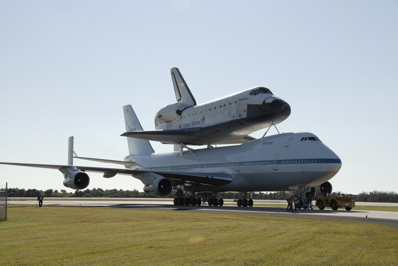CAPE CANAVERAL, Fla. -- The shuttle carrier aircraft, or SCA, and its piggyback passenger space shuttle Endeavour stop on the parking apron of the Shuttle Landing Facility runway at NASA's Kennedy Space Center in Florida after landing. The SCA will be towed into the mate/demate device that will lift the shuttle and put it back on the ground. After making the three-day trip from California, touchdown at Kennedy was at 2:44 p.m. EST. The SCA is a modified Boeing 747 jetliner. Endeavour landed at Edwards Air Force Base in California Nov. 30 to end mission STS-126. The return to Kennedy began Dec. 8 and took four days after stops across the country for fuel. The last stop was at Barksdale Air Force Base in Shreveport, La. Weather conditions en route and in Florida postponed the landing at Kennedy until Dec. 12. Photo credit: NASA/Kim Shiflett