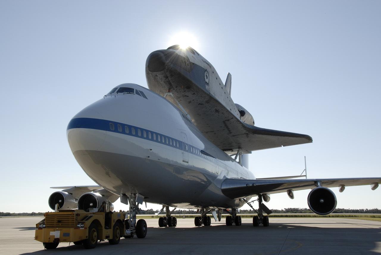 CAPE CANAVERAL, Fla. -- The shuttle carrier aircraft, or SCA, and its piggyback passenger space shuttle Endeavour are towed toward the mate/demate device at the Shuttle Landing Facility at NASA's Kennedy Space Center in Florida. The device will lift the shuttle and put it back on the ground. After making the three-day trip from California, touchdown at Kennedy was at 2:44 p.m. EST. The SCA is a modified Boeing 747 jetliner. Endeavour landed at Edwards Air Force Base in California Nov. 30 to end mission STS-126. The return to Kennedy began Dec. 8 and took four days after stops across the country for fuel. The last stop was at Barksdale Air Force Base in Shreveport, La. Weather conditions en route and in Florida postponed the landing at Kennedy until Dec. 12. Photo credit: NASA/Kim Shiflett