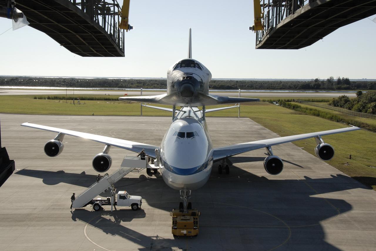 CAPE CANAVERAL, Fla. -- The shuttle carrier aircraft, or SCA, and its piggyback passenger space shuttle Endeavour are posed to enter the mate/demate device at the Shuttle Landing Facility at NASA's Kennedy Space Center in Florida. The device will lift the shuttle and put it back on the ground. After making the three-day trip from California, touchdown at Kennedy was at 2:44 p.m. EST. The SCA is a modified Boeing 747 jetliner. Endeavour landed at Edwards Air Force Base in California Nov. 30 to end mission STS-126. The return to Kennedy began Dec. 8 and took four days after stops across the country for fuel. The last stop was at Barksdale Air Force Base in Shreveport, La. Weather conditions en route and in Florida postponed the landing at Kennedy until Dec. 12. Photo credit: NASA/Kim Shiflett