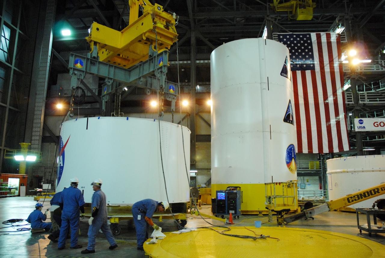 CAPE CANAVERAL, Fla. --  In high bay 4 of the Vehicle Assembly Building at NASA's Kennedy Space Center in Florida, a crane is attached to segment 5 of the Ares I-X upper stage simulator segments to lift it.  Segment 5  will be stacked on to segment 4, at the top of the tall stack at right. The upper stage simulator comprises 11 segments, each approximately 18 feet in diameter, that will be used in the test flight known as Ares I-X in 2009.  The simulator segments will simulate the mass and the outer mold line.  The upper stage accounts for nearly one-quarter of the total height of the Ares I.  It will take the Ares I on the second phase of its journey from Earth, providing the guidance, navigation and control needed for the second phase of the Ares I ascent flight.   Photo credit: NASA/Jim Grossmann