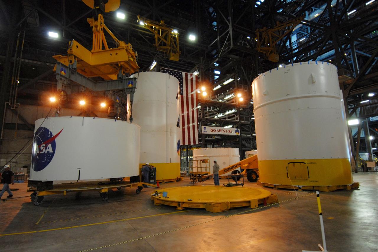CAPE CANAVERAL, Fla. --   In high bay 4 of the Vehicle Assembly Building at NASA's Kennedy Space Center in Florida, a crane lifts segment 5 of the Ares I-X upper stage simulator segments.  It will be placed on segment 4, at top of the tall stack behind it. The upper stage simulator comprises 11 segments, each approximately 18 feet in diameter, that will be used in the test flight known as Ares I-X in 2009.  The simulator segments will simulate the mass and the outer mold line.  The upper stage accounts for nearly one-quarter of the total height of the Ares I.  It will take the Ares I on the second phase of its journey from Earth, providing the guidance, navigation and control needed for the second phase of the Ares I ascent flight.   Photo credit: NASA/Troy Cryder