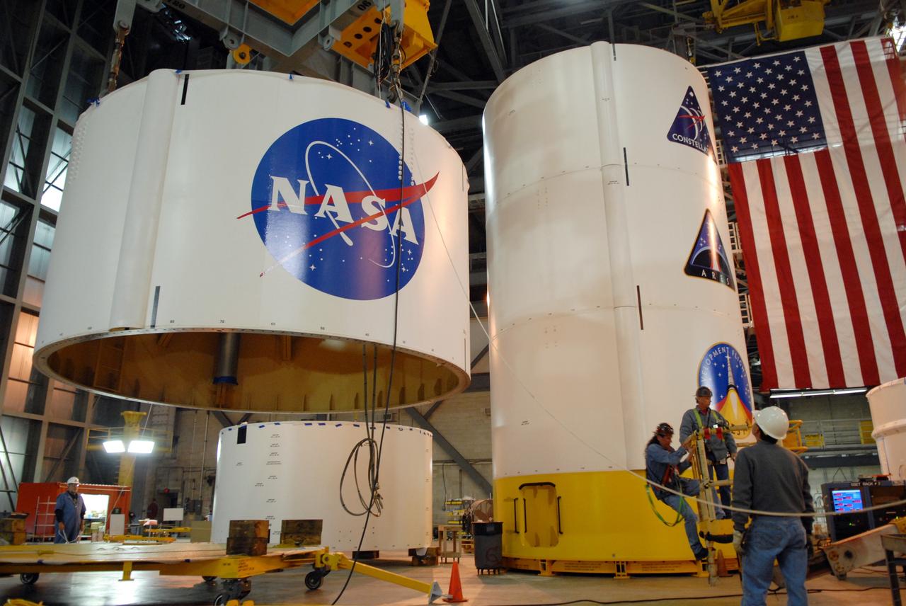 CAPE CANAVERAL, Fla. --  In high bay 4 of the Vehicle Assembly Building at NASA's Kennedy Space Center in Florida, a crane lifts segment 5 of the Ares I-X upper stage simulator segments.  It will be placed on segment 4, at top of the tall stack behind it. The upper stage simulator comprises 11 segments, each approximately 18 feet in diameter, that will be used in the test flight known as Ares I-X in 2009.  The simulator segments will simulate the mass and the outer mold line.  The upper stage accounts for nearly one-quarter of the total height of the Ares I.  It will take the Ares I on the second phase of its journey from Earth, providing the guidance, navigation and control needed for the second phase of the Ares I ascent flight.   Photo credit: NASA/Troy Cryder