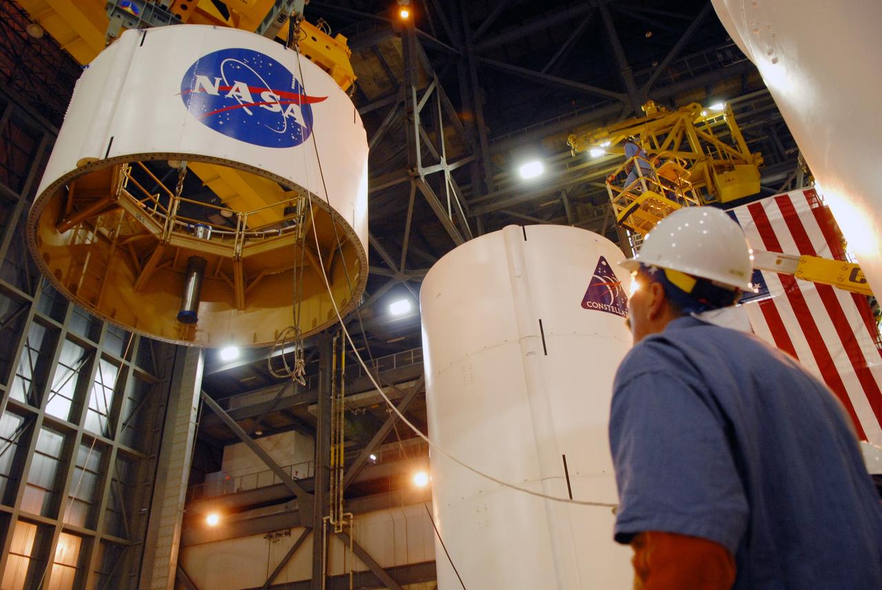 CAPE CANAVERAL, Fla. -- In high bay 4 of the Vehicle Assembly Building at NASA's Kennedy Space Center in Florida, a crane lifts segment 5 of the Ares I-X upper stage simulator segments toward the tall stack behind it.  Segment 5 will be placed on segment 4, at top of the tall stack. The upper stage simulator comprises 11 segments, each approximately 18 feet in diameter, that will be used in the test flight known as Ares I-X in 2009.  The simulator segments will simulate the mass and the outer mold line.  The upper stage accounts for nearly one-quarter of the total height of the Ares I.  It will take the Ares I on the second phase of its journey from Earth, providing the guidance, navigation and control needed for the second phase of the Ares I ascent flight.   Photo credit: NASA/Troy Cryder