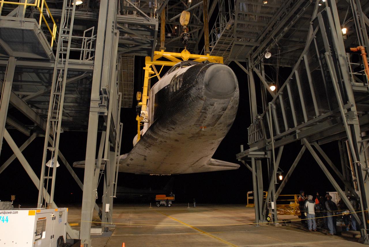 CAPE CANAVERAL, Fla. -- Before dawn, at the Shuttle Landing Facility, or SLF, at NASA's Kennedy Space Center in Florida, space shuttle Endeavour is lowered toward the ground by the sling in the mate/demate device. After Endeavour is on the ground, it will be towed via the two-mile tow-way from the SLF by a diesel-powered tractor to the Orbiter Processing Facility where it will begin preparations for its next mission, STS-127, targeted for May 2009. Photo credit: NASA/Jim Grossmann