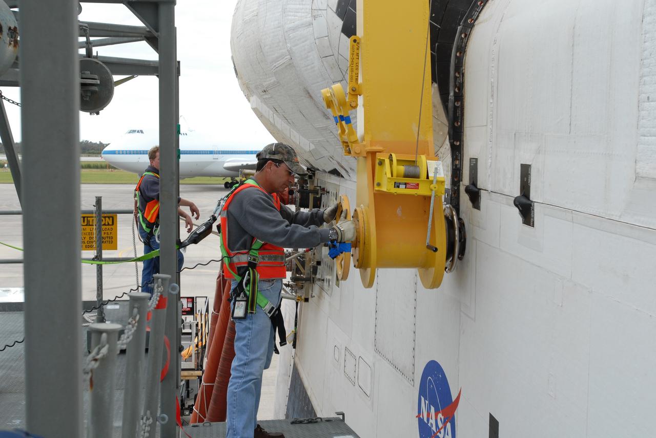 CAPE CANAVERAL, Fla. --   At the Shuttle Landing Facility, or SLF, at NASA's Kennedy Space Center in Florida, workers begin removing the sling from around space shuttle Endeavour.  Part of the mate/demate device, the sling enabled Endeavour to be lifted away from shuttle carrier aircraft, or SCA, and lowered to the ground. The SCA carried the shuttle piggyback from California, where Endeavour landed Nov. 30 to end the STS-126 mission. Endeavour will be towed via the two-mile tow-way from the SLF by a diesel-powered tractor to the Orbiter Processing Facility where it will begin preparations for its next mission, STS-127, targeted for May 2009. Photo credit: NASA/Jim Grossmann
