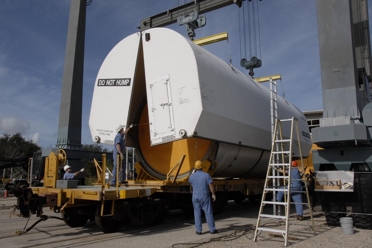 CAPE CANAVERAL, Fla. --   At the NASA Railroad yard at NASA's Kennedy Space Center, a protective cover is being placed over the solid rocket booster, or SRB, segment from the STS-126 launch.  The segments will be taken to Utah. After a mission, the spent boosters are recovered, cleaned, disassembled, refurbished and reused for another launch. After the segments are  hydrolased inside, they are placed on flatbed trucks and transferred to the NASA Railroad yard. The NASA Railroad locomotive backs up the rail cars and the segments are lowered onto the car. After being covered for the trip, the segments will be moved to Titusville for interchange with Florida East Coast Railway to begin the trip back to Utah.  Photo credit: NASA/Kim Shiflett