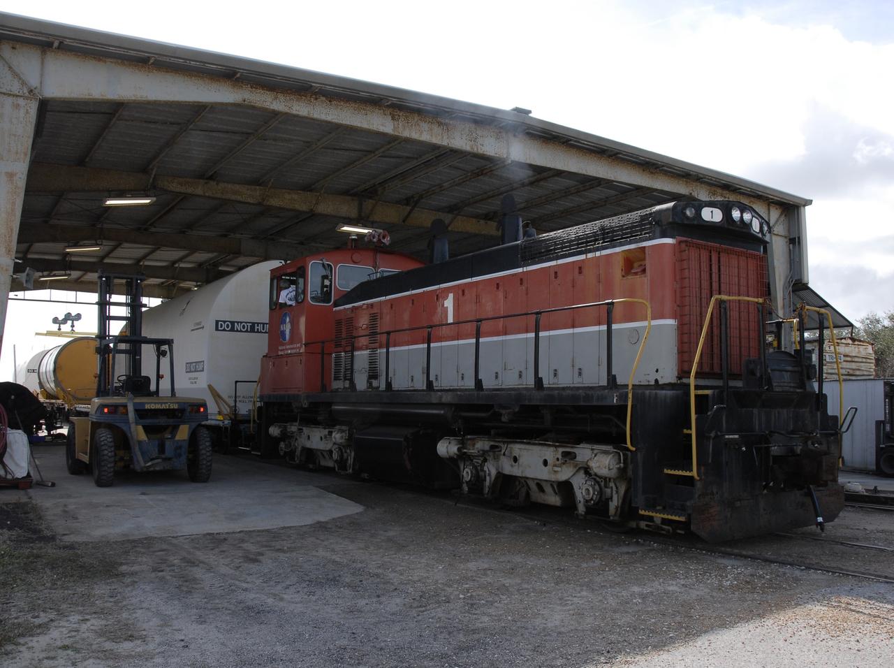 CAPE CANAVERAL, Fla. -- At the NASA Railroad yard at NASA's Kennedy Space Center, the locomotive moves the train for another cover to be lowered onto place around one of the solid rocket booster, or SRB, segments from the STS-126 launch. The segments will be taken to Utah. After a mission, the spent boosters are recovered, cleaned, disassembled, refurbished and reused for another launch. After the segments are hydrolased inside, they are placed on flatbed trucks and transferred to the NASA Railroad yard. The NASA Railroad locomotive backs up the rail cars and the segments are lowered onto the cars. After being covered for the trip, the segments are moved to Titusville for interchange with Florida East Coast Railway to begin the trip back to Utah. Photo credit: NASA/Kim Shiflett