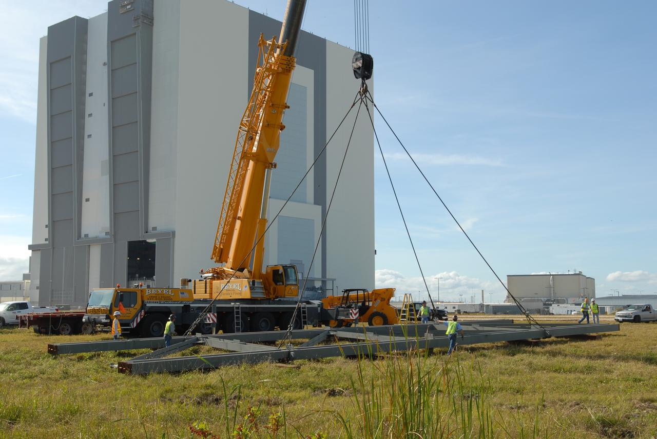 CAPE CANAVERAL, Fla. --   Near the Vehicle Assembly Building at NASA's Kennedy Space Center in Florida, a crane places on the ground one of the trusses, T4, to build the new mobile launcher for the Constellation Program.  The new mobile launcher will be the base for the Ares rockets to launch the Orion crew exploration vehicle and the cargo vehicle.  The base is being made lighter than space shuttle mobile launcher platforms so the crawler-transporter can pick up the added load of the 345-foot tower and taller rocket.  When the structural portion of the new mobile launcher is complete, umbilicals, access arms, communications equipment and command/control equipment will be installed. Photo credit: NASA/Jim Grossmann