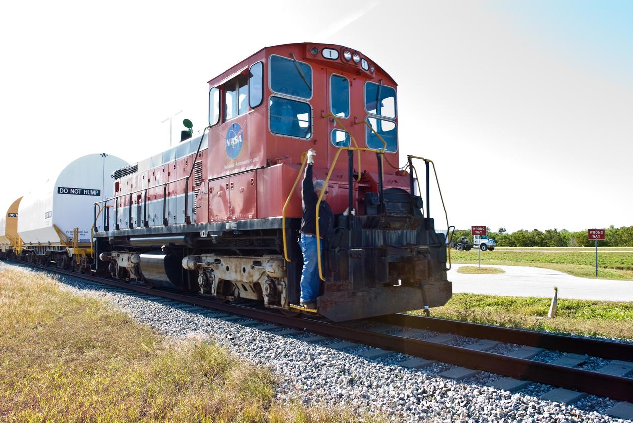CAPE CANAVERAL, Fla. -- From the NASA Railroad yard at NASA's Kennedy Space Center, the train hauling the solid rocket booster, or SRB, segments recovered from space shuttle Endeavour's STS-126 launch in November heads for Titusville, Fla., for interchange with Florida East Coast Railway to begin the trip back to Utah. The SRB segments are under protective covers. Photo credit: NASA/Jim Grossmann