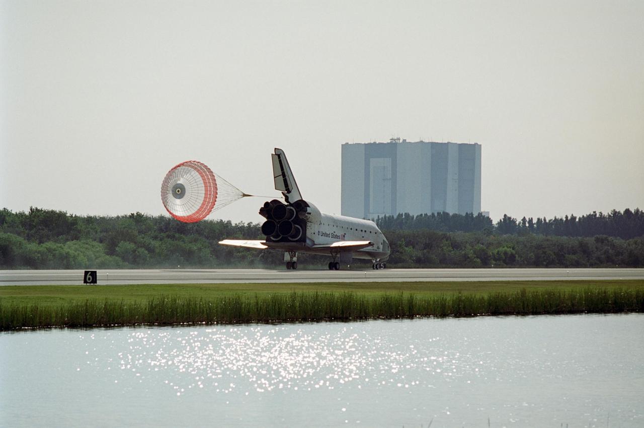 KENNEDY SPACE CENTER, FLA. -- After a nearly 5.3 million mile round trip to the International Space Station, space shuttle Atlantis slows down with the aid of a drag chute after landing on Runway 15 of the Shuttle Landing Facility at NASA's Kennedy Space Center. In the background is the Vehicle Assembly Building. The shuttle landed on orbit 202 to complete the 13-day STS-122 mission. Main gear touchdown was 9:07:10 a.m. Nose gear touchdown was 9:07:20 a.m. Wheel stop was at 9:08:08 a.m. Mission elapsed time was 12 days, 18 hours, 21 minutes and 44 seconds. During the mission, Atlantis' crew installed the new Columbus laboratory, leaving a larger space station and one with increased science capabilities. The Columbus Research Module adds nearly 1,000 cubic feet of habitable volume and affords room for 10 experiment racks, each an independent science lab. Photo credit: NASA/Kenny Allen, Robert Murray