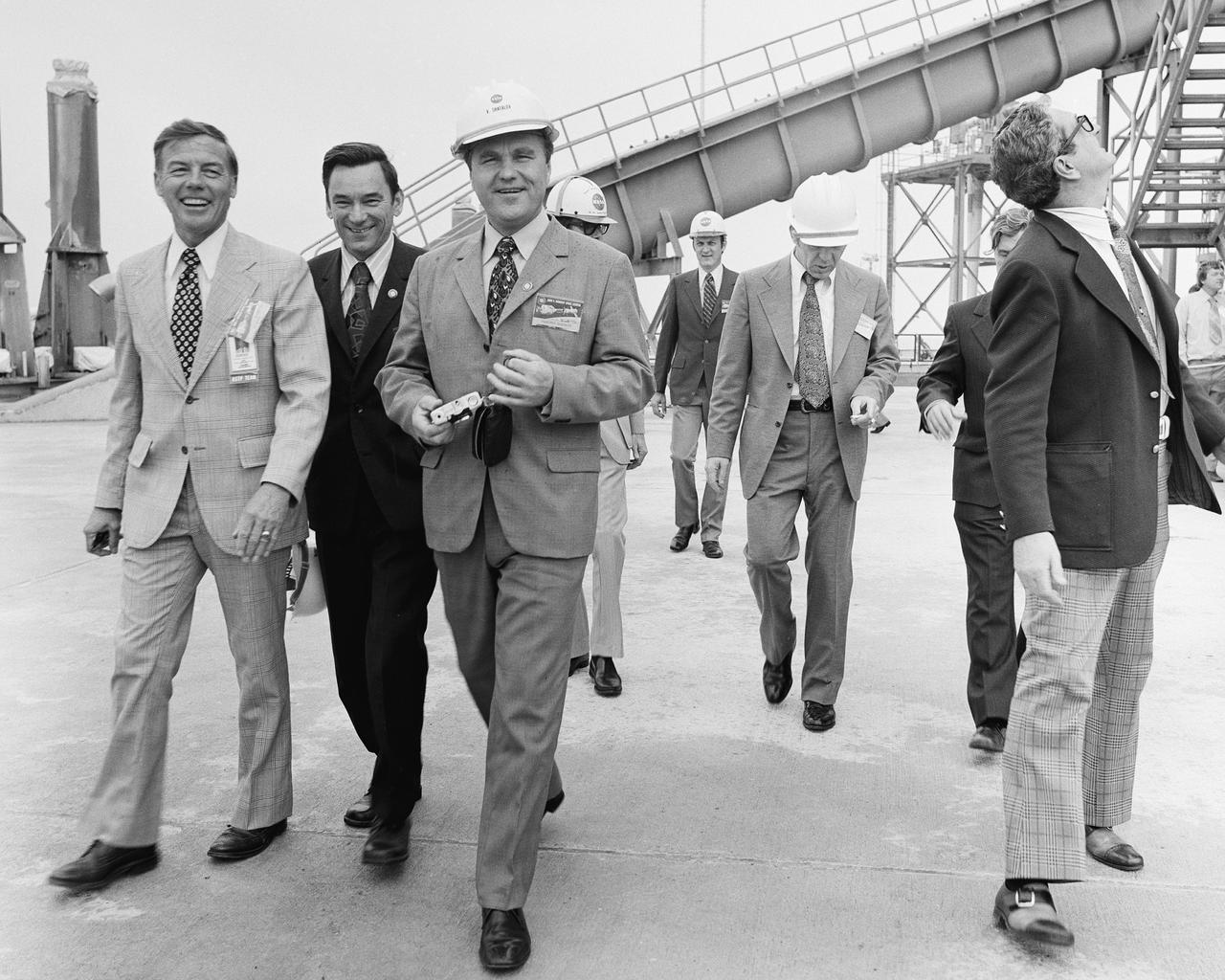 CAPE CANAVERAL, Fla. – KSC Director Lee Scherer, left, escorts a Soviet interpreter and Vladimir Shatalov, Soviet Cosmonaut Training Chief, on a tour of Pad 39B at the Spaceport. The Soviet and American personnel connected with July's Apollo Soyuz Test Project were at KSC February 8-10 to inspect equipment and tour facilities. The first international crewed spaceflight was a joint U.S.-U.S.S.R. rendezvous and docking mission. The Apollo-Soyuz Test Project, or ASTP, took its name from the spacecraft employed: the American Apollo and the Soviet Soyuz. The three-man Apollo crew lifted off from Kennedy Space Center aboard a Saturn IB rocket on July 15, 1975, to link up with the Soyuz that had launched a few hours earlier. A cylindrical docking module served as an airlock between the two spacecraft for transfer of the crew members. Photo credit: NASA