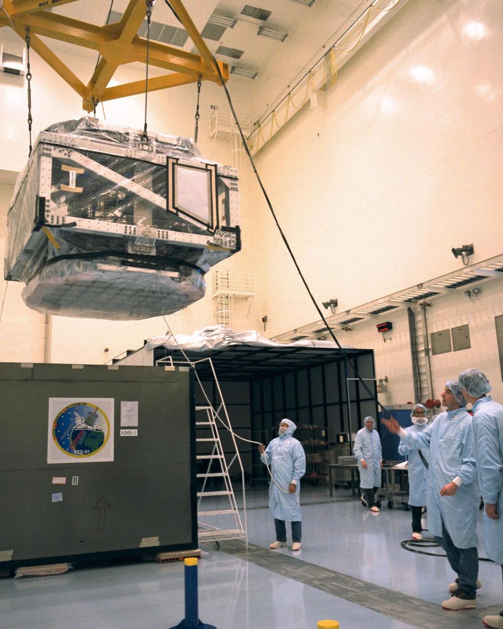 Technicians assist in moving the alpha-magnetic spectrometer (AMS-1) from its protective shipping case in KSC’s Multi Payload Processing Facility (MPPF). The STS-91 payload arrived at KSC in January and is scheduled to be flown on the 9th and final Mir docking mission, scheduled for launch in May. The objectives of the AMS-1 investigation are to search for anti-matter and dark matter in space and to study astrophysics. The STS-91 flight crew includes Commander Charles Precourt; Pilot Dominic Gorie; and Mission Specialists Wendy B. Lawrence; Franklin Chang-Diaz, Ph.D.; Janet Kavandi, Ph.D.; and Valery Ryumin, with the Russian Space Agency. After docking with the Russian Space Station Mir, Mission Specialist Andrew Thomas, Ph.D., will join the STS-91 crew and return to Earth aboard Discovery
