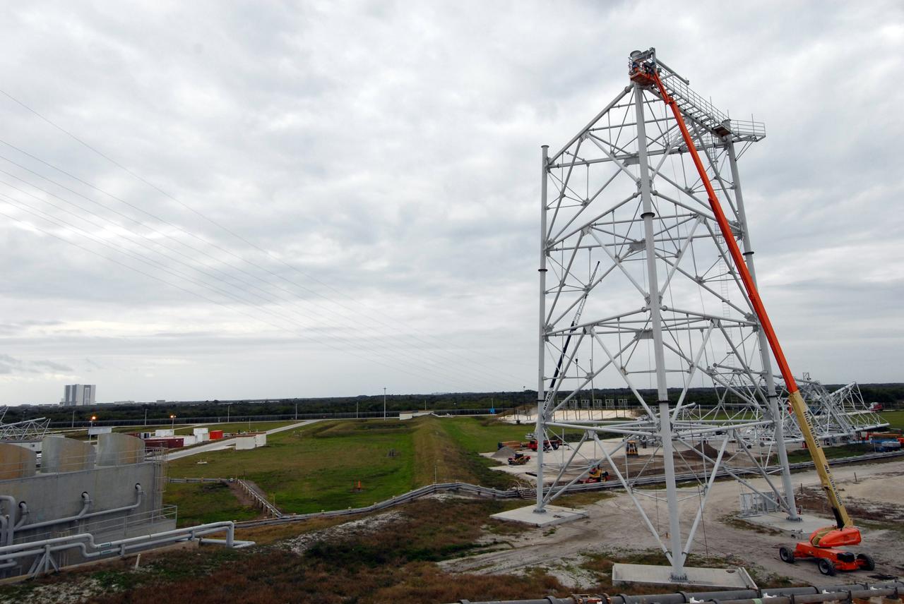 CAPE CANAVERAL, Fla. –  CAPE CANAVERAL, Fla. -- On Launch Pad 39B at NASA's Kennedy Space Center in Florida, another lightning tower is being constructed as part of the new lightning protection system for the Constellation Program and Ares/Orion launches. Each of the three new lightning towers will be 500 feet tall with an additional 100-foot fiberglass mast atop supporting a wire catenary system. This improved lightning protection system allows for the taller height of the Ares I rocket compared to the space shuttle. Pad 39B will be the site of the first Ares vehicle launch, including the Ares I-X test flight that is targeted for July 2009. Photo credit: NASA/Troy Cryder
