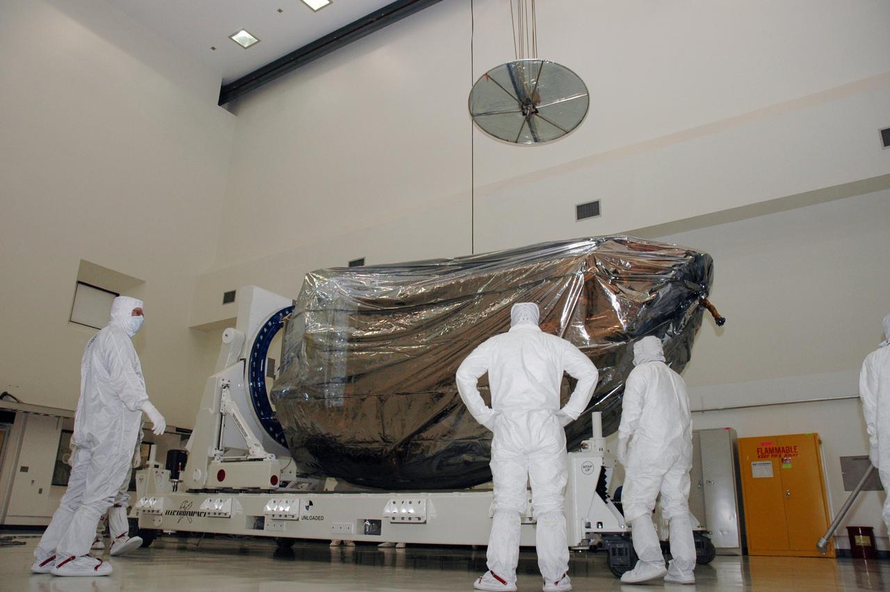 CAPE CANAVERAL, Fla. -- In a clean room at the Astrotech payload processing facility in Titusville, Fla., workers prepare to rotate NASA's Kepler spacecraft. Kepler will then be uncovered and prepared for initial testing. A NASA Discovery mission, Kepler is specifically designed to survey our region of the Milky Way galaxy to discover hundreds of Earth-size and smaller planets in or near the habitable zone and determine how many of the billions of stars in our galaxy have such planets. Results from this mission will allow us to place our solar system within the continuum of planetary systems in the Galaxy. After processing at Astrotech, Kepler will be carried to its launch pad at Cape Canaveral. NASA's planet-hunting Kepler mission is scheduled to launch no earlier than March 5 atop a Delta II rocket. Photo credit: NASA/Chris Rhodes