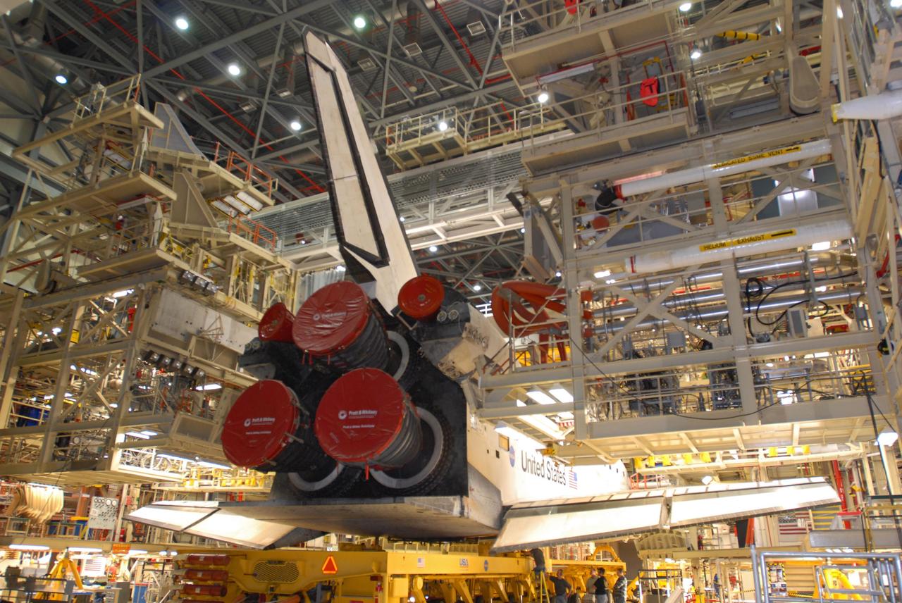 CAPE CANAVERAL, Fla. -- In Orbiter Processing Facility 3 at NASA's Kennedy Space Center in Florida, space shuttle Discovery is lowered onto a transporter for its move to the Vehicle Assembly Building at NASA's Kennedy Space Center. In the VAB, Discovery will be attached to its external fuel tank and twin solid rocket boosters. After additional preparations are made, the shuttle will be rolled out to Launch Pad 39A for a targeted launch to the International Space Station on Feb. 12. Photo credit: NASA/Jim Grossmann
