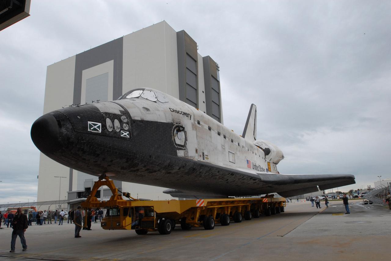 CAPE CANAVERAL, Fla. -- Space shuttle Discovery rolls out of Orbiter Processing Facility 3 at NASA's Kennedy Space Center in Florida to head to the Vehicle Assembly Building (in the background). First motion was at 2:30 p.m. EST. In the VAB, Discovery will be attached to its external fuel tank and twin solid rocket boosters. After additional preparations are made, the shuttle will be rolled out to Launch Pad 39A for a targeted launch to the International Space Station on Feb. 12. Photo credit: NASA/Jim Grossmann