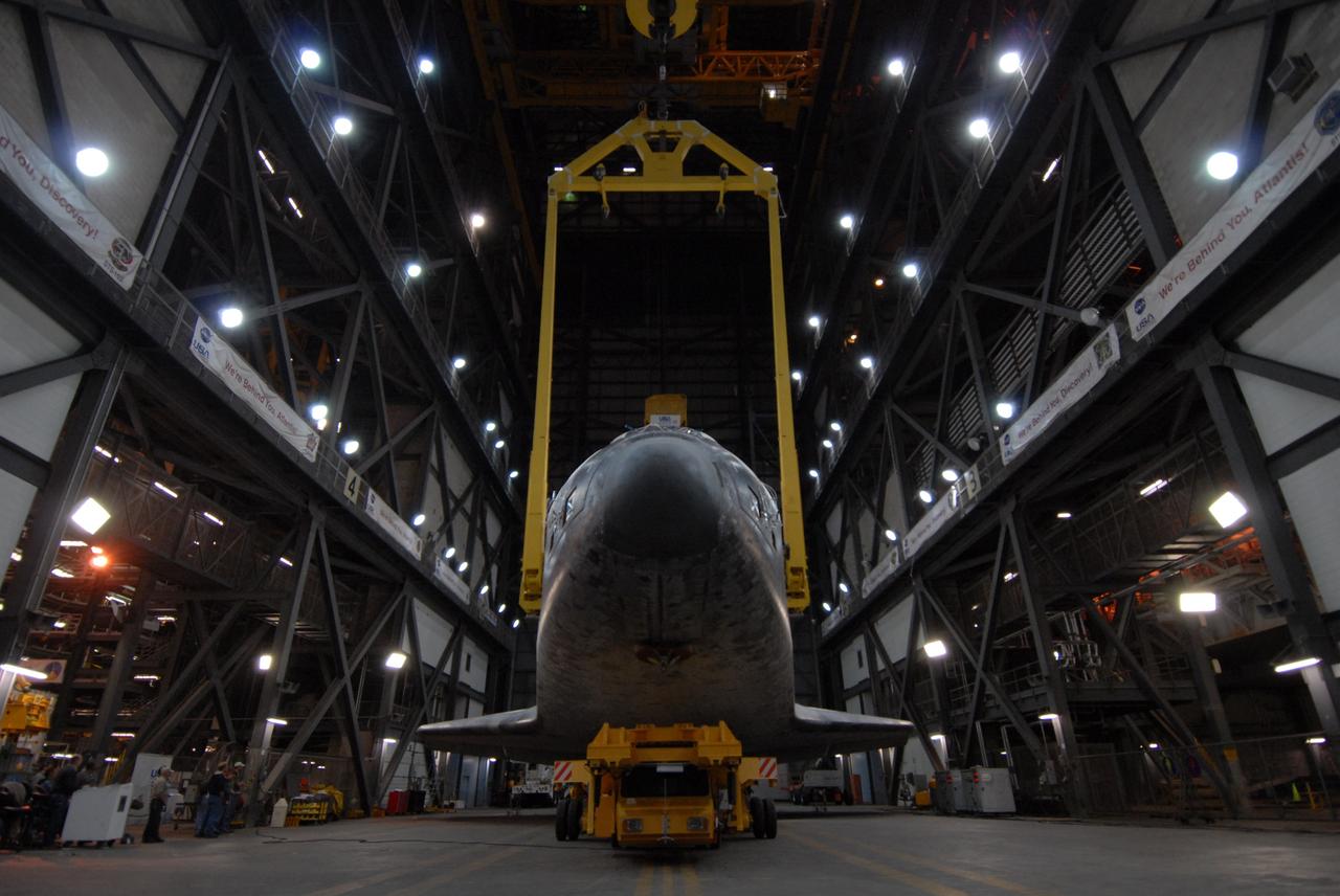 CAPE CANAVERAL, Fla. -- In the Vehicle Assembly Building transfer aisle at NASA's Kennedy Space Center in Florida, space shuttle Discovery is lifted from its transporter by an overhead crane. The shuttle will be raised to a vertical position and lifted into high bay 3 where it will be mated with its external fuel tank and solid rocket boosters on the mobile launcher platform. After additional preparations are made, the shuttle will be rolled out to Launch Pad 39A for a targeted launch on Feb. 12. Discovery will carry the final starboard truss (S6) in the assembly of the International Space Station. Photo credit: NASA/Troy Cryder