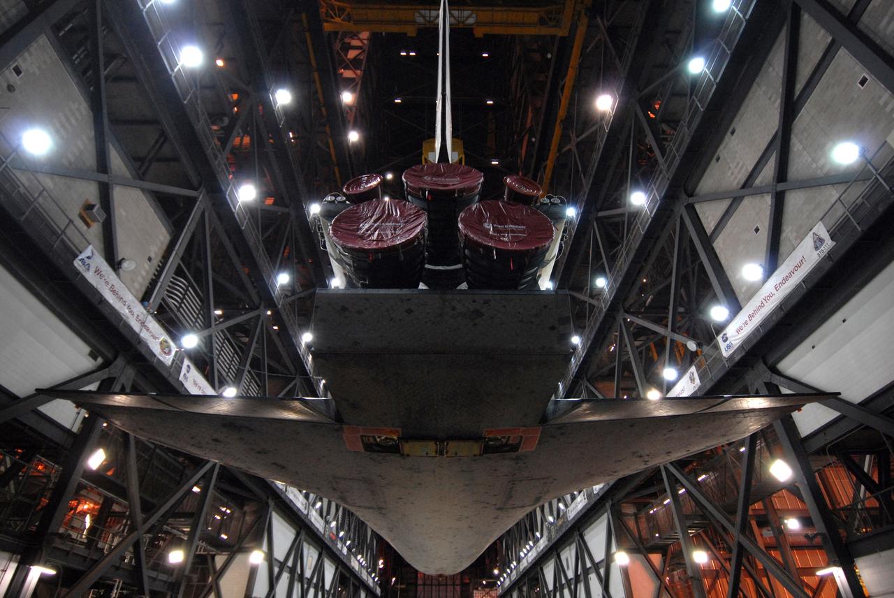 CAPE CANAVERAL, Fla. -- In the Vehicle Assembly Building transfer aisle at NASA's Kennedy Space Center in Florida, space shuttle Discovery is viewed from underneath as it is lifted from its transporter by an overhead crane. The shuttle will be raised to a vertical position and lifted into high bay 3 where it will be mated with its external fuel tank and solid rocket boosters on the mobile launcher platform. After additional preparations are made, the shuttle will be rolled out to Launch Pad 39A for a targeted launch on Feb. 12. Discovery will carry the final starboard truss (S6) in the assembly of the International Space Station. Photo credit: NASA/Troy Cryder