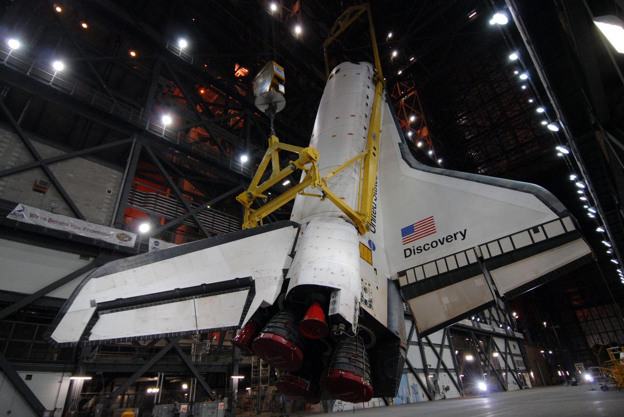 CAPE CANAVERAL, Fla. -- In the Vehicle Assembly Building at NASA's Kennedy Space Center in Florida, space shuttle Discovery is raised to a vertical position above the transfer aisle. The shuttle will be lifted into high bay 3 where it will be mated with its external fuel tank and solid rocket boosters on the mobile launcher platform. After additional preparations are made, the shuttle will be rolled out to Launch Pad 39A for a targeted launch on Feb. 12. Discovery will carry the final starboard truss (S6) in the assembly of the International Space Station. Photo credit: NASA/Jack Pfaller