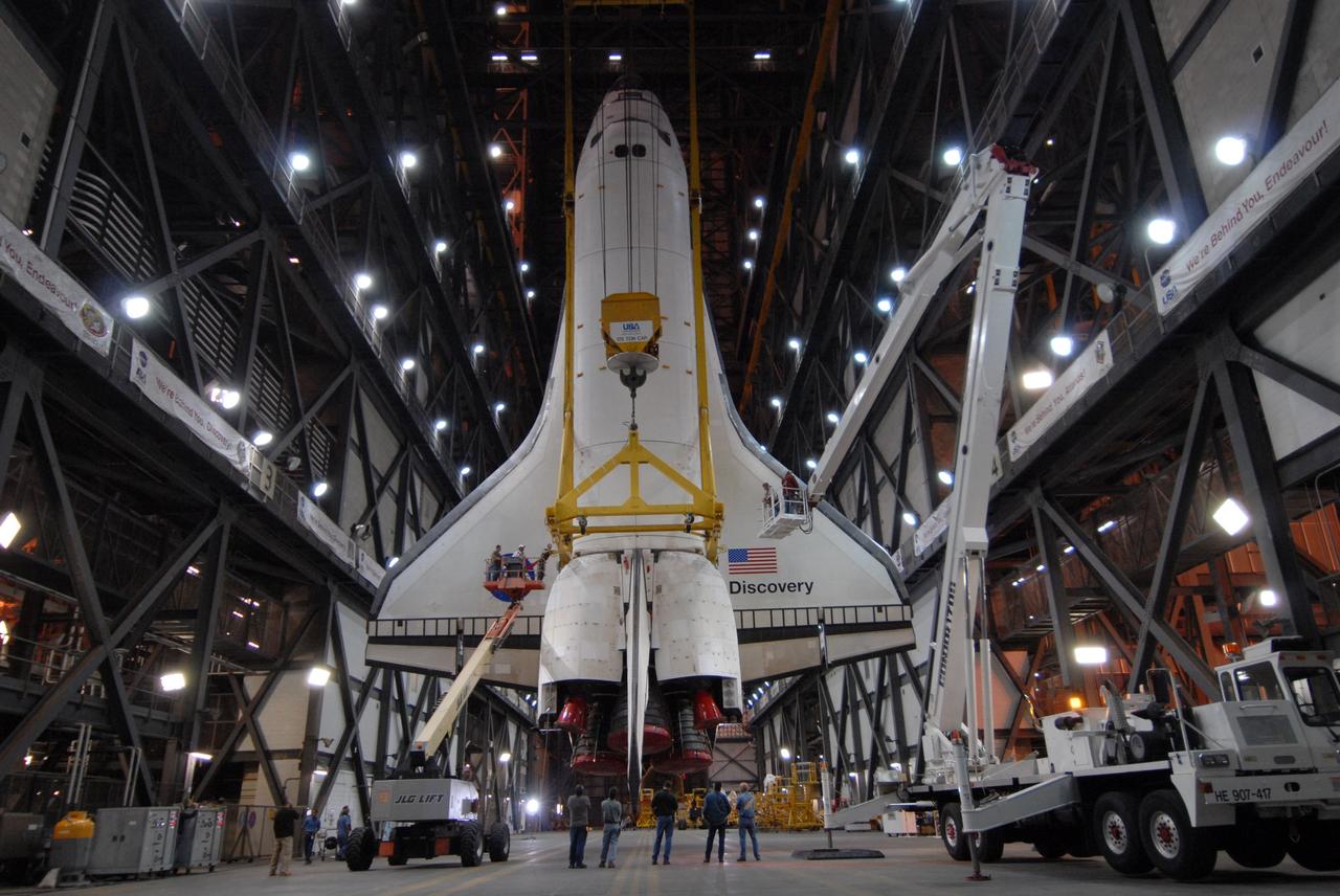 CAPE CANAVERAL, Fla. -- In the Vehicle Assembly Building at NASA's Kennedy Space Center in Florida, space shuttle Discovery is suspended vertically above the transfer aisle. The shuttle will be lifted into high bay 3 where it will be mated with its external fuel tank and solid rocket boosters on the mobile launcher platform. After additional preparations are made, the shuttle will be rolled out to Launch Pad 39A for a targeted launch on Feb. 12. Discovery will carry the final starboard truss (S6) in the assembly of the International Space Station. Photo credit: NASA/Jack Pfaller