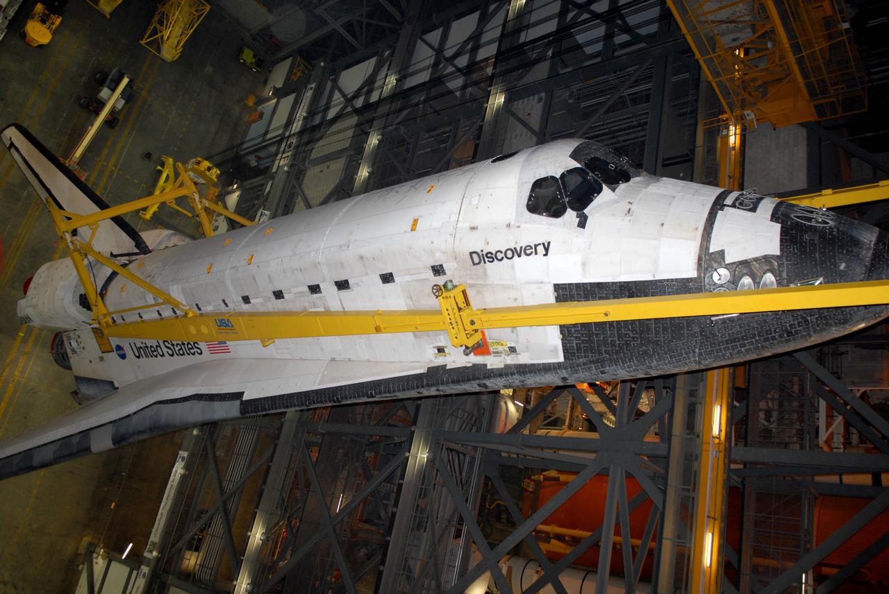 CAPE CANAVERAL, Fla. -- In the Vehicle Assembly Building at NASA's Kennedy Space Center in Florida, space shuttle Discovery is lifted into the upper levels for transfer to high bay 3. The shuttle will then be lowered onto the mobile launcher platform for mating with its external fuel tank and solid rocket boosters. After additional preparations are made, the shuttle will be rolled out to Launch Pad 39A for a targeted launch on Feb. 12. Discovery will carry the final starboard truss (S6) in the assembly of the International Space Station. Photo credit: NASA/Jack Pfaller