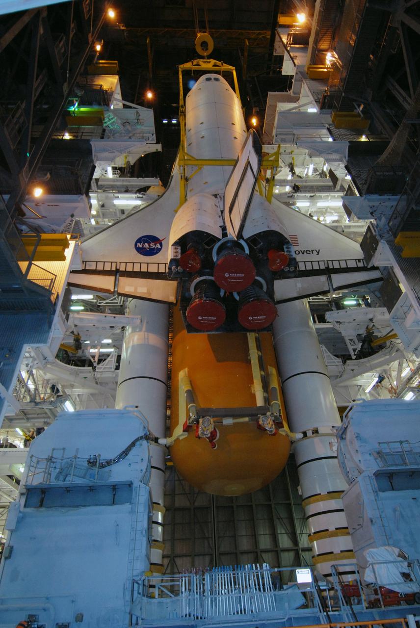 CAPE CANAVERAL, Fla. -- In the Vehicle Assembly Building at NASA's Kennedy Space Center in Florida, space shuttle Discovery is lowered into high bay 3 alongside the external fuel tank and solid rocket boosters are already stacked on the mobile launcher platform. Discovery will be mated with the stack. After additional preparations are made, the shuttle will be rolled out to Launch Pad 39A for a targeted launch on Feb. 12. Discovery will carry the final starboard truss (S6) in the assembly of the International Space Station. Photo credit: NASA/Jack Pfaller