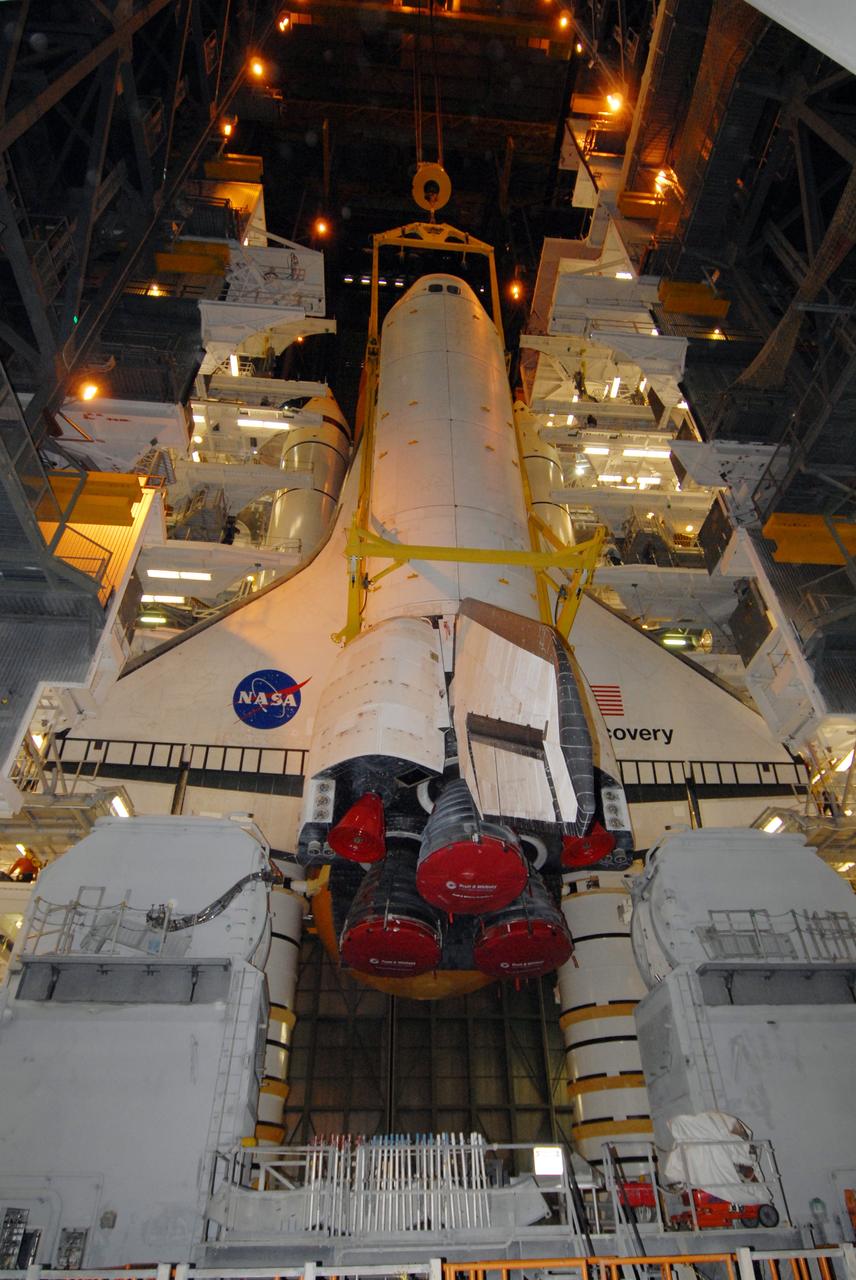 CAPE CANAVERAL, Fla. -- In the Vehicle Assembly Building at NASA's Kennedy Space Center in Florida, space shuttle Discovery is lowered alongside the external fuel tank and solid rocket boosters already stacked on the mobile launcher platform. Discovery will be mated with the stack. After additional preparations are made, the shuttle will be rolled out to Launch Pad 39A for a targeted launch on Feb. 12. Discovery will carry the final starboard truss (S6) in the assembly of the International Space Station. Photo credit: NASA/Jack Pfaller