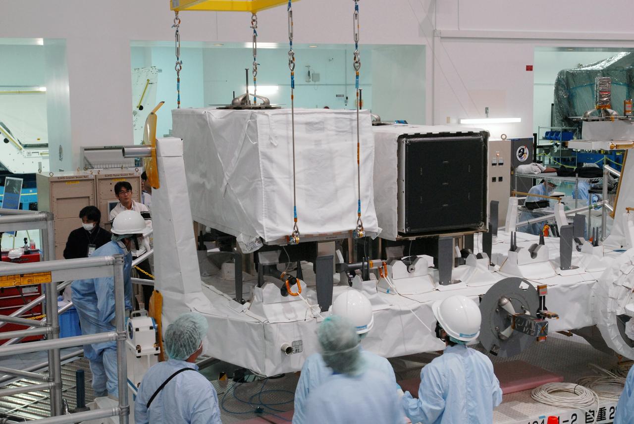 CAPE CANAVERAL, Fla. -- In the Space Station Processing Facility at NASA's Kennedy Space Center in Florida, a crane lowers the MAXI (Monitor of All-sky X-ray Image) onto the Payload Attachment Mechanism on the Japanese Experiment Module's Experiment Logistics Module-Exposed Section, or ELM-ES. It is being installed next to the SEDA-AP (Space Environment Data Acquisition Equipment-Attached Payload). The MAXI and SEDA-AP are part of space shuttle Endeavour's payload on the STS-127 mission. Using X-ray slit cameras with high sensitivity, the MAXI will continuously monitor astronomical X-ray objects over a broad energy band (0.5 to 30 keV). Endeavour is targeted to launch May 15. Photo credit: NASA/Jim Grossmann