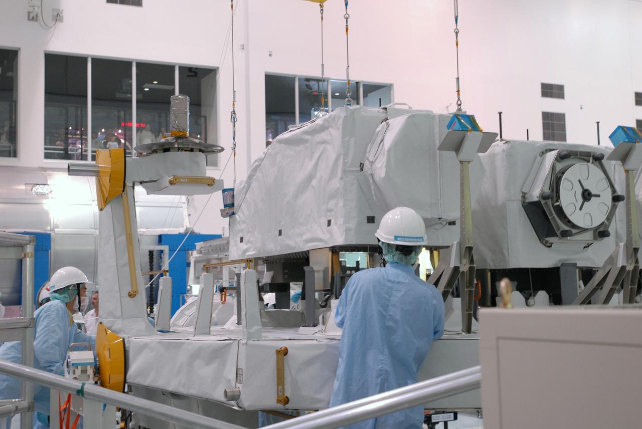 CAPE CANAVERAL, Fla. --  In the Space Station Processing Facility at NASA's Kennedy Space Center in Florida, an overhead crane lowers the ICS Exposed Facility, or ICS-EF, onto the Japanese Experiment Module's Experiment Logistics Module-Exposed Section, or ELM-ES, for installation. The ICS-EF is composed of several components, including an antenna, pointing mechanism, frequency converters, high-power amplifier and various sensors including the Earth sensor, Sun sensor and inertial reference unit. The ICS-EF is part of space shuttle Endeavour's payload on the STS-127 mission, targeted for launch on May 15. Photo credit: NASA/Jim Grossmann