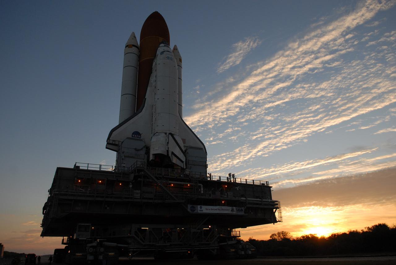 CAPE CANAVERAL, Fla. -- Space shuttle Discovery is silhouetted against the dawn's early light as it makes the slow 3.4-mile journey to Launch Pad 39A. The shuttle sits atop the mobile launcher platform, which are being moved by the massive crawler-transporter beneath. First motion out of the Vehicle Assembly Building was at 5:17 a.m. EST. Discovery is targeted to launch to the International Space Station Feb. 12. During Discovery's 14-day mission, the crew will install the S6 truss segment and its solar arrays to the starboard side of the station, completing the station's backbone, or truss, enabling a six-person crew to live there starting in May. Photo credit: NASA/Troy Cryder