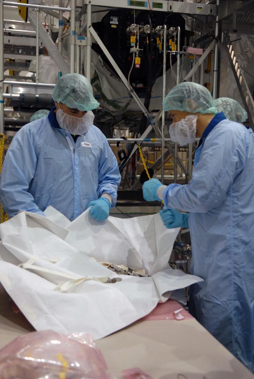 CAPE CANAVERAL, Fla. – In the Space Station Processing Facility at NASA's Kennedy Space Center in Florida, members of the STS-127 Mission Specialists Chris Cassidy and Tom Marshburn review options of how they will stow the excess thermal blankets on the Japanese Experiment Module's Experiment Logistics Module-Exposed Section, or ELM-ES, after they remove them on-orbit. The crew members are at Kennedy for Crew Equipment Interface Test activities, or CEIT, which provides experience handling tools, equipment and hardware for the mission.  The payload will be launched to the International Space Station aboard space shuttle Endeavour on the STS-127 mission, targeted for launch on May 15. Photo credit: NASA/Dimitrios Gerondidakis