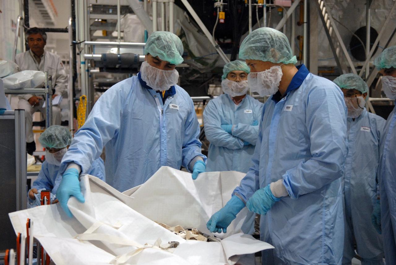 CAPE CANAVERAL, Fla. –  In the Space Station Processing Facility at NASA's Kennedy Space Center in Florida, members of the STS-127 Mission Specialists Chris Cassidy and Tom Marshburn review options of how they will stow the excess thermal blankets on the Japanese Experiment Module's Experiment Logistics Module-Exposed Section, or ELM-ES, after they remove them on-orbit. The crew members are at Kennedy for Crew Equipment Interface Test activities, or CEIT, which provides experience handling tools, equipment and hardware for the mission.  The payload will be launched to the International Space Station aboard space shuttle Endeavour on the STS-127 mission, targeted for launch on May 15. Photo credit: NASA/Dimitrios Gerondidakis