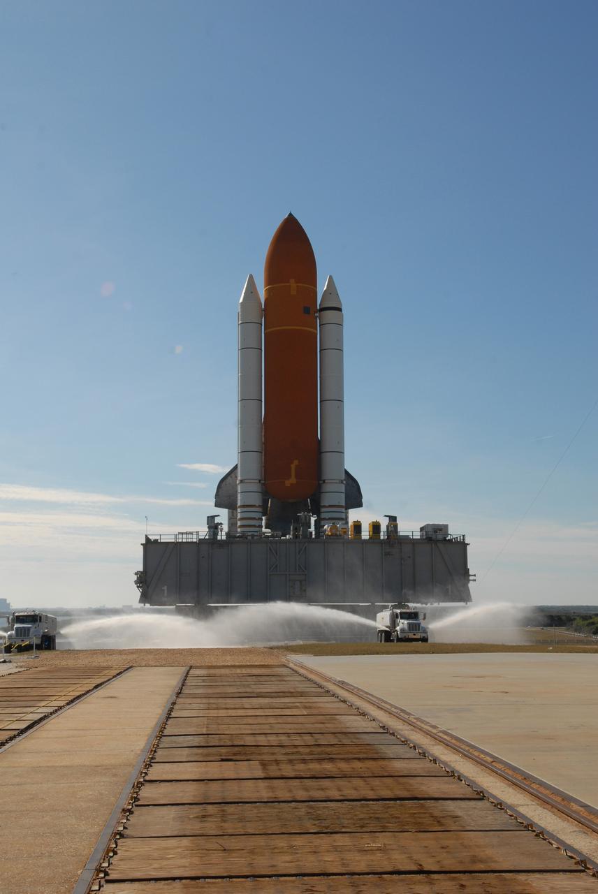 CAPE CANAVERAL, Fla. --  Water trucks spray the crawlerway at NASA's Kennedy Space Center in Florida to reduce dust as space shuttle Discovery, atop the mobile launcher platform and crawler-transporter, makes the slow journey onto Launch Pad 39A.  First motion out of the Vehicle Assembly Building was at 5:17 a.m. EST.  Discovery was secured to the pad at 12:16 p.m. Discovery is targeted to launch to the International Space Station Feb. 12. During Discovery's 14-day mission, the crew will install the S6 truss segment and its solar arrays to the starboard side of the station, completing the station's backbone, or truss, enabling a six-person crew to live there starting in May.  Photo credit: NASA/Troy Cryder
