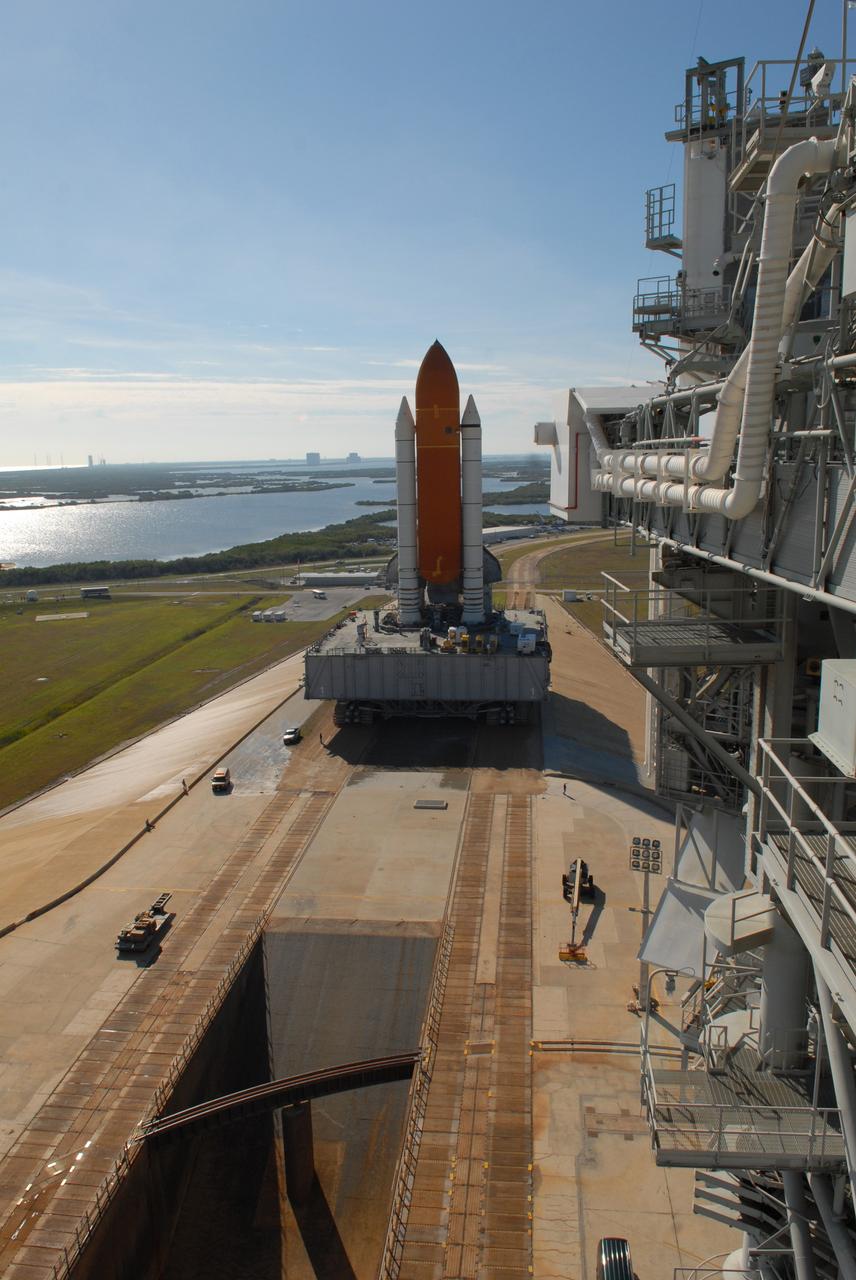 CAPE CANAVERAL, Fla. --  Space shuttle Discovery, atop the mobile launcher platform and crawler-transporter, reaches the top of Launch Pad 39A at NASA's Kennedy Space Center in Florida.  in the foreground is the flame trench, which the launcher platform will straddle for launch.  At right is the rotating service structure.  Behind the shuttle, the grounds of the space center spread out toward the horizon.  Discovery's first motion out of the Vehicle Assembly Building was at 5:17 a.m. EST.  Discovery was secured to the pad at 12:16 p.m. Discovery is targeted to launch to the International Space Station Feb. 12. During Discovery's 14-day mission, the crew will install the S6 truss segment and its solar arrays to the starboard side of the station, completing the station's backbone, or truss, enabling a six-person crew to live there starting in May.  Photo credit: NASA/Troy Cryder