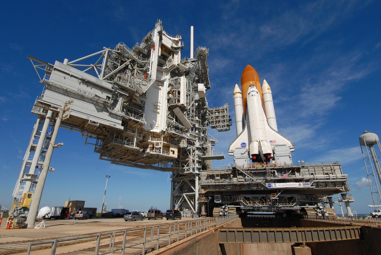 CAPE CANAVERAL, Fla. -- Space shuttle Discovery rests on Launch Pad 39A after a seven-hour rollout from the Vehicle Assembly Building at NASA's Kennedy Space Center in Florida. At left are the fixed service structure (next to the shuttle) and the rotating service structure.  First motion was at 5:17 a.m. EST.  Discovery was secured to the pad at 12:16 p.m.  Discovery is targeted to launch to the International Space Station Feb. 12. During Discovery's 14-day mission, the crew will install the S6 truss segment and its solar arrays to the starboard side of the station, completing the station's backbone, or truss, enabling a six-person crew to live there starting in May.  Photo credit: NASA/Troy Cryder