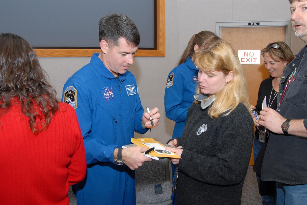 CAPE CANAVERAL, Fla. – At NASA's Kennedy Space Center in Florida, STS-126 crew members sign autographs for Kennedy workers who attended the astronauts' presentation of their experiences during the mission. Mission Specialist Shane Kimbrough is at left. In the background is Mission Specialist Heidemarie Stefanyshyn-Piper. Photo credit: NASA/Dimitrios Gerondidakis