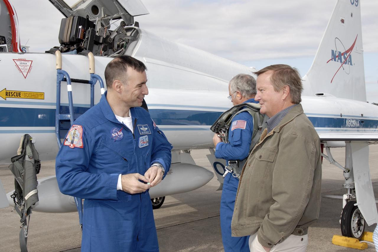 CAPE CANAVERAL, Fla. –  After arriving at NASA's Kennedy Space Center in Florida on a T-38 jet training aircraft, STS-119 Commander Lee Archambault (left) is greeted by Shuttle Launch Director Mike Leinbach.  Behind them is Mission Specialist John Phillips.  The crew flew to Kennedy to take part in terminal countdown demonstration test activities, which include equipment familiarization and emergency exit training and culminate in a simulated launch countdown. Photo credit: NASA/Kim Shiflett