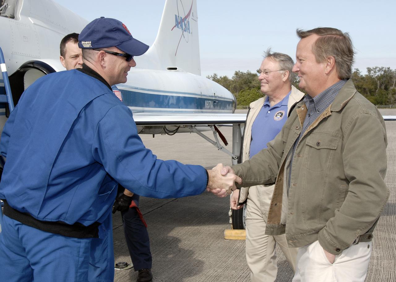 CAPE CANAVERAL, Fla. –   After arriving at NASA's Kennedy Space Center in Florida on a T-38 jet training aircraft, STS-119 Pilot Tony Antonelli is greeted by Shuttle Launch Director Mike Leinbach (right).  Next to Leinbach is Jerry Ross, chief of the Vehicle Integration Test Office.  Behind Antonelli is Mission Specialist Richard Arnold. The crew flew to Kennedy to take part in terminal countdown demonstration test activities, which include equipment familiarization and emergency exit training and culminate in a simulated launch countdown. Photo credit: NASA/Kim Shiflett