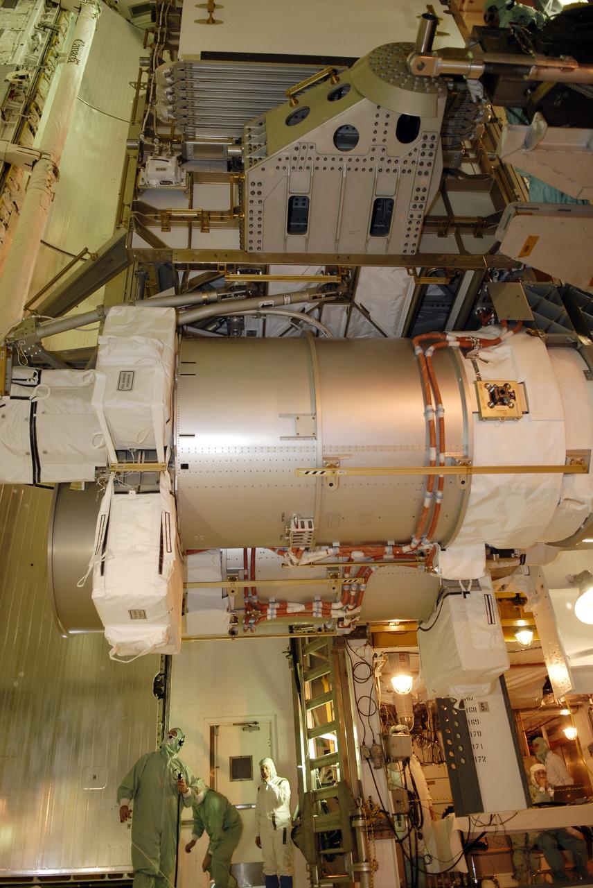 CAPE CANAVERAL, Fla. – In the Payload Changeout Room on Launch Pad 39A at NASA's Kennedy Space Center in Florida, workers check the progress of the payload for the STS-119 mission as it is transferred to space shuttle Discovery's cargo bay (bottom of photo). The payload consists of the integrated truss structure S6 and solar arrays. During Discovery's 14-day mission, the shuttle's seven astronauts will install the S6 truss segment and solar arrays to the starboard side of the International Space Station, completing the station's truss, or backbone. Launch of Discovery on the STS-119 mission is targeted for Feb. 12. Photo credit: NASA/Kim Shiflett