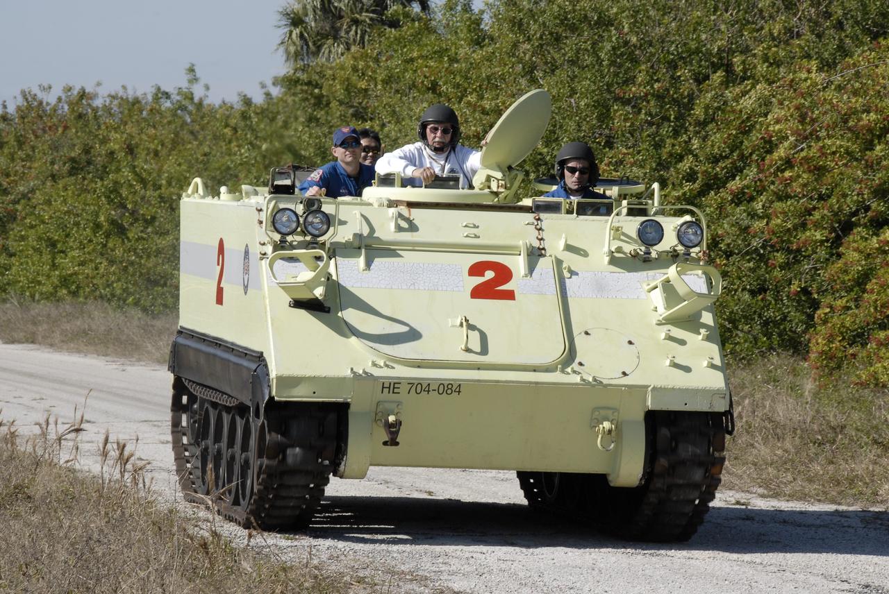 CAPE CANAVERAL, Fla. – At NASA's Kennedy Space Center in Florida, STS-119 Commander Lee Archambault drives the M-113 armored personnel carrier used for emergency escape, if needed, from Launch Pad 39A. Next to him in front is astronaut rescue team leader Capt. George Hoggard. Behind is Pilot Tony Antonelli and Mission Specialist Koichi Wakata, who represents the Japan Aerospace Exploration Agency. The crew members are at Kennedy for prelaunch preparation known as terminal countdown demonstration test, or TCDT. The training provides astronauts and ground crews with an opportunity to participate in various simulated countdown activities, including equipment familiarization and a simulated launch countdown. The crew of space shuttle Discovery is targeted to launch on the STS-119 mission Feb. 12. During Discovery's 14-day mission, the crew will install the S6 truss segment and solar arrays to the starboard side of the International Space Station, completing the station's truss, or backbone. Photo credit: NASA/Kim Shiflett