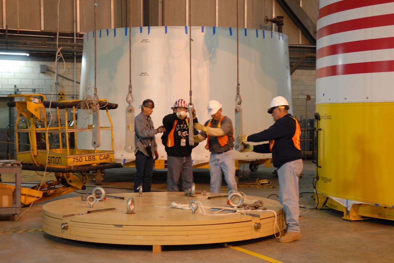 CAPE CANAVERAL, Fla. –    In high bay 4 of the Vehicle Assembly Building at NASA's Kennedy Space Center in Florida, workers get ready to attach cables to the ballast for installation in the Ares I-X segments. These ballast assemblies will be installed in the upper stage 1 and 7 segments and will mimic the mass of the fuel. Their total weight is approximately 160,000 pounds.  Ares I-X is the test vehicle for the Ares I, which is part of the Constellation Program to return men to the moon and beyond.  Ares I is the essential core of a safe, reliable, cost-effective space transportation system that eventually will carry crewed missions back to the moon, on to Mars and out into the solar system. Ares I may also use its 25-ton payload capacity to deliver resources and supplies to the International Space Station, or to "park" payloads in orbit for retrieval by other spacecraft bound for the moon or other destinations. The Ares I-X is targeted for launch in July 2009. Photo credit: NASA/Dimitri Gerondidakis