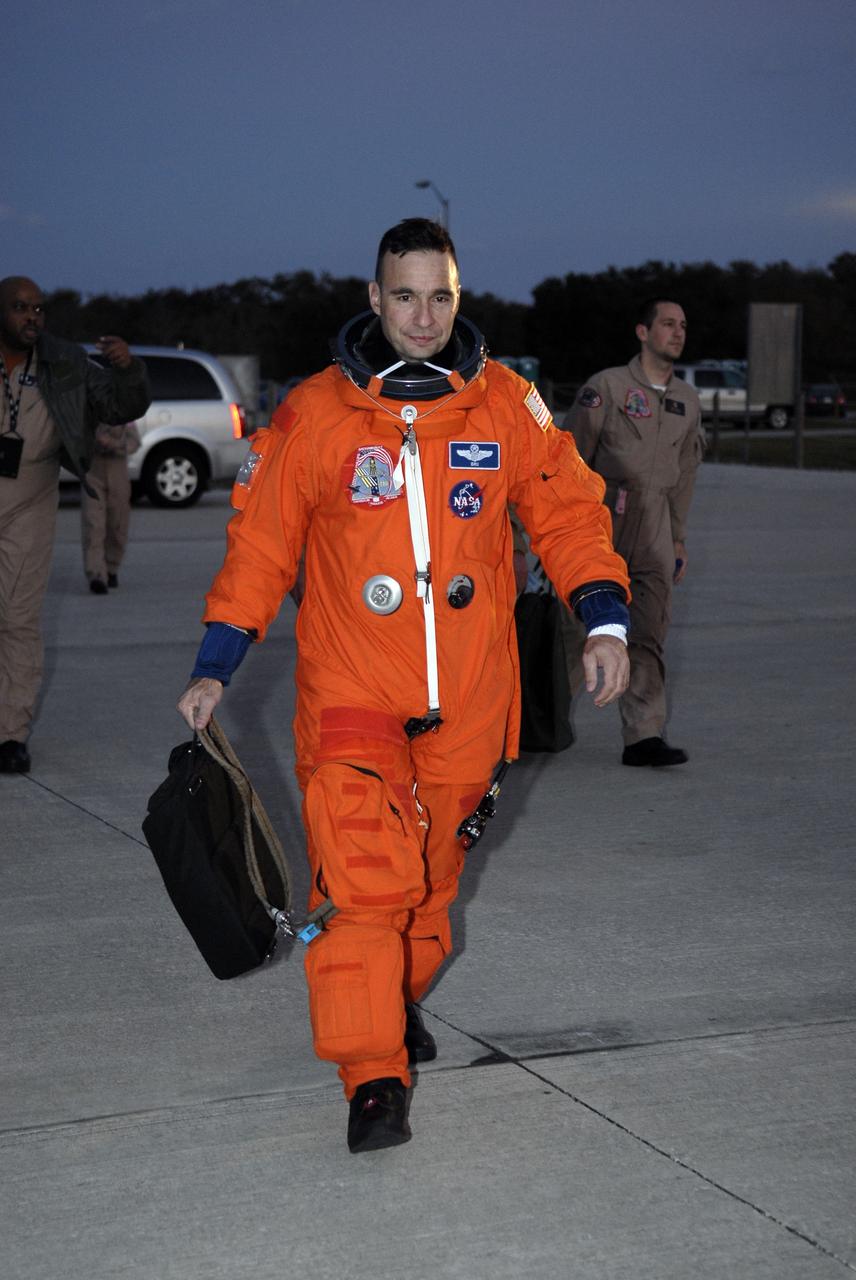 CAPE CANAVERAL, Fla. – STS-119 Commander Lee Archambault heads across the tarmac of the Shuttle Landing Facility at NASA's Kennedy Space Center in Florida to practice shuttle landings in the shuttle training aircraft, or STA.  Archambault and the rest of the crew are at Kennedy to prepare for launch as part of the Terminal Countdown Demonstration Test activities. The TCDT includes equipment familiarization and a simulated launch countdown. The STA is a Grumman American Aviation-built Gulf Stream II jet that was modified to simulate a shuttle’s cockpit, motion and visual cues, and handling qualities. In flight, the aircraft duplicates the shuttle’s atmospheric descent trajectory from approximately 35,000 feet to landing. The crew of space shuttle Discovery is targeted to launch on the STS-119 mission Feb. 12. During Discovery's 14-day mission, the crew will install the S6 truss segment and solar arrays to the starboard side of the International Space Station, completing the station's truss, or backbone.   Photo credit: NASA/Kim Shiflett