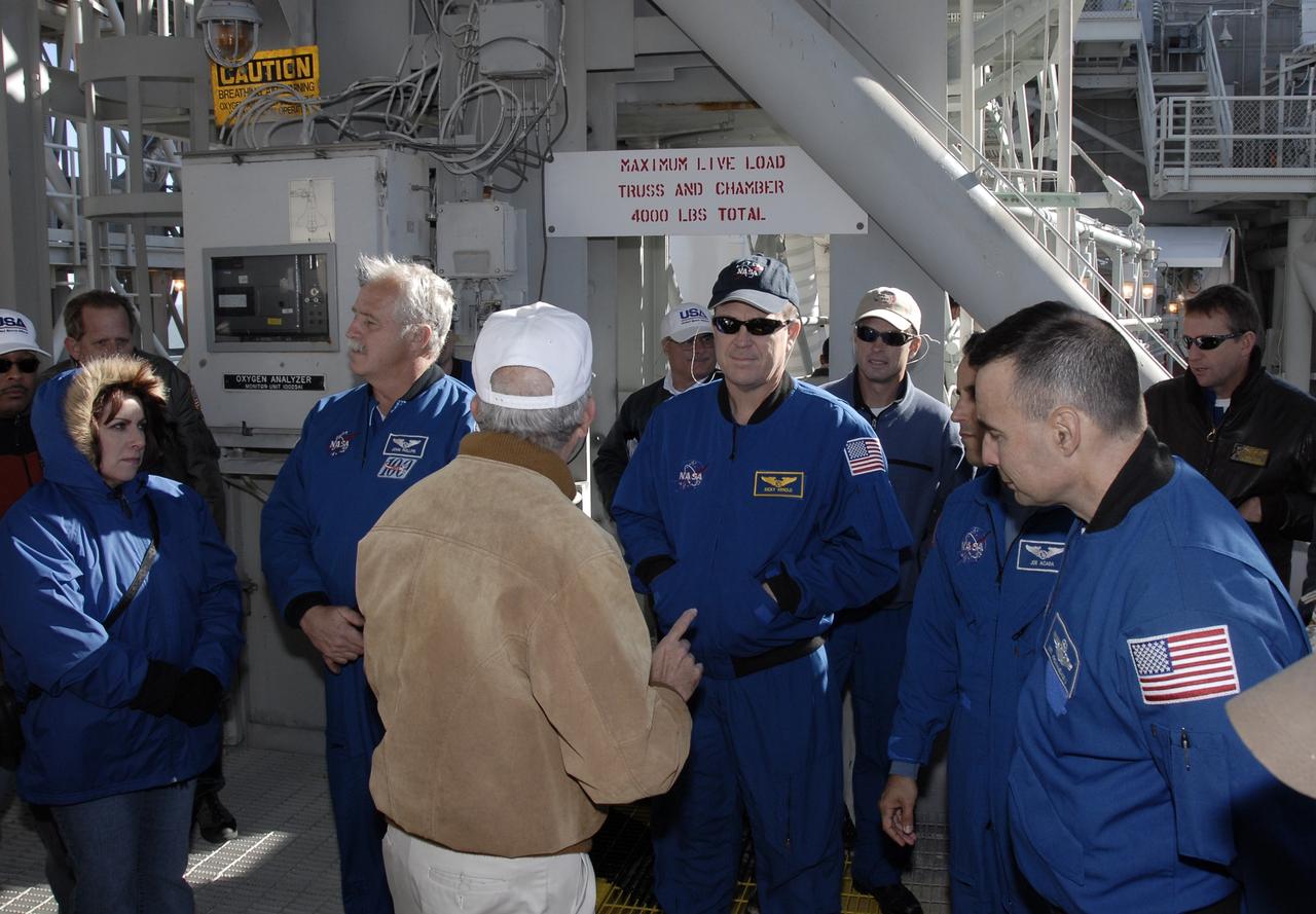 CAPE CANAVERAL, Fla. – The STS-119 crew members gather on the fixed service structure on Launch Pad 39A at NASA's Kennedy Space Center in Florida to listen to the trainer about emergency egress procedures. Left of center is Mission Specialist John Phillips; on the right are Mission Specialists Richard Arnold, Steve Swanson and Joseph Acaba and Commander Lee Archambault. The astronauts are at Kennedy to prepare for launch as part of the Terminal Countdown Demonstration Test activities. The TCDT includes equipment familiarization and a simulated launch countdown. The crew of space shuttle Discovery is targeted to launch on the STS-119 mission Feb. 12. During Discovery's 14-day mission, the crew will install the S6 truss segment and solar arrays to the starboard side of the International Space Station, completing the station's truss, or backbone. Photo credit: NASA/Kim Shiflett