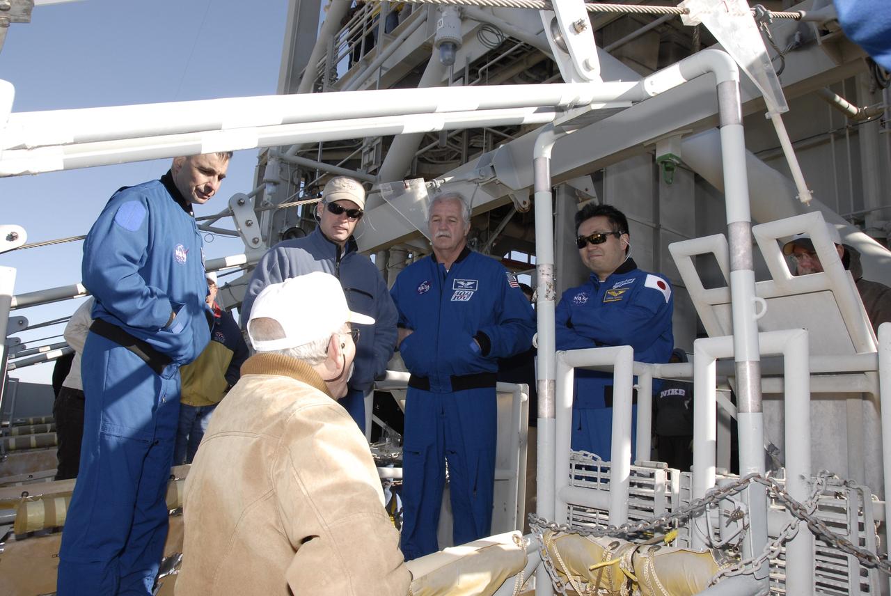 CAPE CANAVERAL, Fla. – On the fixed service structure on Launch Pad 39A at NASA's Kennedy Space Center in Florida, STS-119 crew members listen to a trainer about emergency egress procedures from the slidewire basket area. From left are Commander Lee Archambault and Mission Specialists Steve Swanson, John Phillips and Koichi Wakata. The astronauts are at Kennedy to prepare for launch as part of the Terminal Countdown Demonstration Test activities. The TCDT includes equipment familiarization and a simulated launch countdown. The crew of space shuttle Discovery is targeted to launch on the STS-119 mission Feb. 12. During Discovery's 14-day mission, the crew will install the S6 truss segment and solar arrays to the starboard side of the International Space Station, completing the station's truss, or backbone. Photo credit: NASA/Kim Shiflett