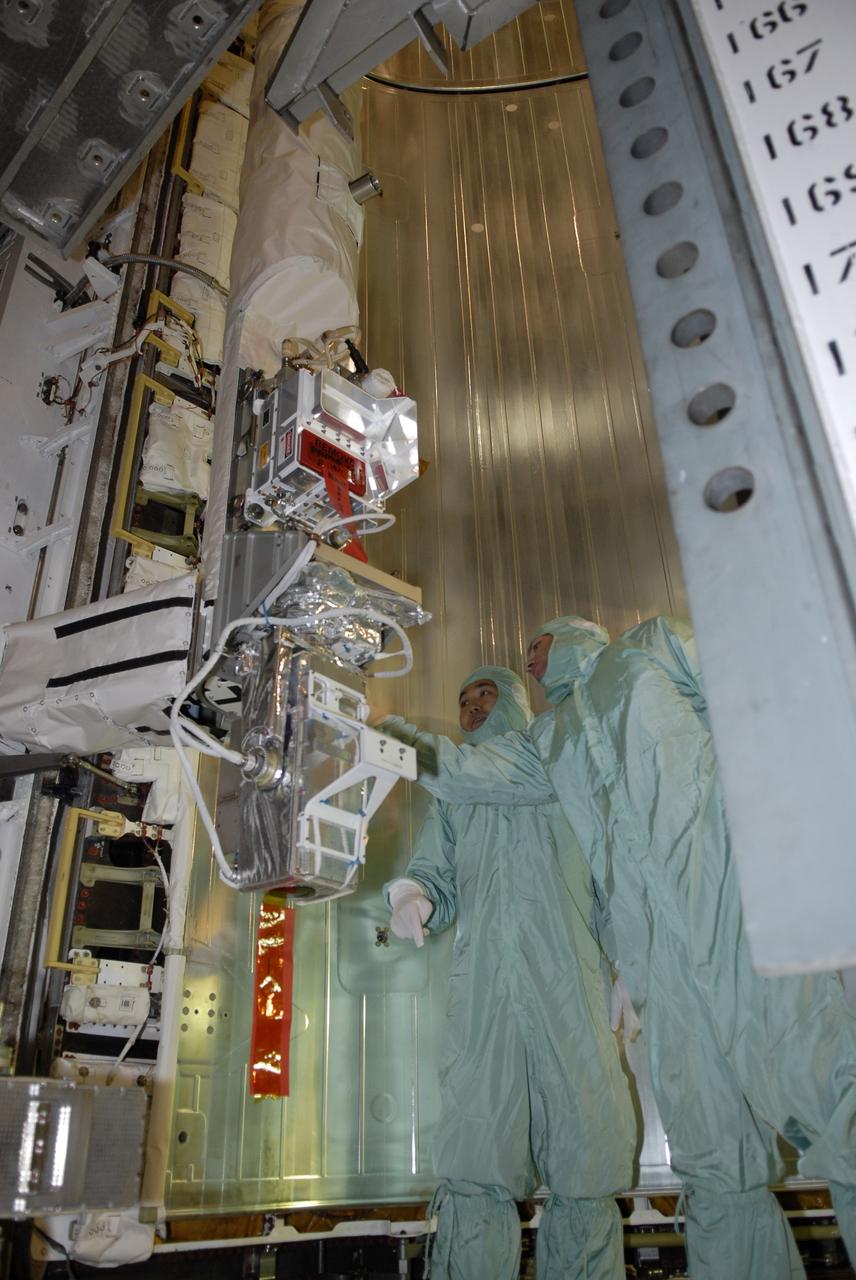 CAPE CANAVERAL, Fla. – On Launch Pad 39A at NASA's Kennedy Space Center in Florida, STS-119 crew members get a close look at the cargo installed in space shuttle Discovery's payload bay. On the left is Mission Specialist Koichi Wakata. The cargo consists of the integrated truss structure S6 and solar arrays. The astronauts are at Kennedy to prepare for launch through Terminal Countdown Demonstration Test activities. The TCDT includes equipment familiarization and a simulated launch countdown. Discovery is targeted to launch on the STS-119 mission Feb. 12. During Discovery's 14-day mission, the crew will install the S6 truss segment and solar arrays to the starboard side of the International Space Station, completing the station's truss, or backbone. Photo credit: NASA/Kim Shiflett