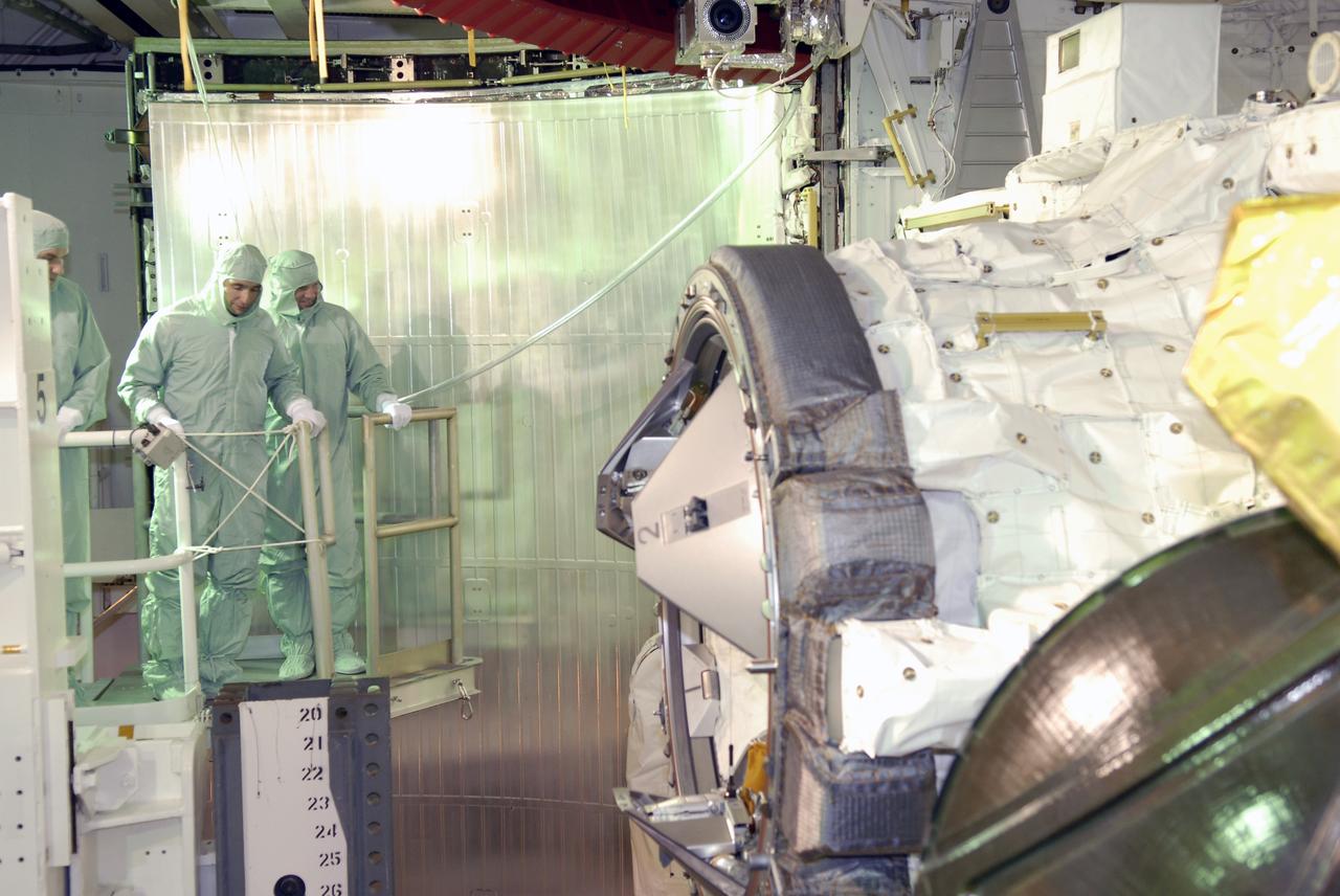 CAPE CANAVERAL, Fla. –  On Launch Pad 39A at NASA's Kennedy Space Center in Florida, STS-119 crew members get a close look at the cargo and other hardware installed in space shuttle Discovery's payload bay. At center is Commander Lee Archambault; on his right is Pilot Tony Antonelli.  Seen at right in the payload bay is the docking adapter.  The astronauts are at Kennedy to prepare for launch through Terminal Countdown Demonstration Test activities. The TCDT includes equipment familiarization and a simulated launch countdown. Discovery is targeted to launch on the STS-119 mission Feb. 12. During Discovery's 14-day mission, the crew will install the S6 truss segment and solar arrays to the starboard side of the International Space Station, completing the station's truss, or backbone.   Photo credit: NASA/Kim Shiflett