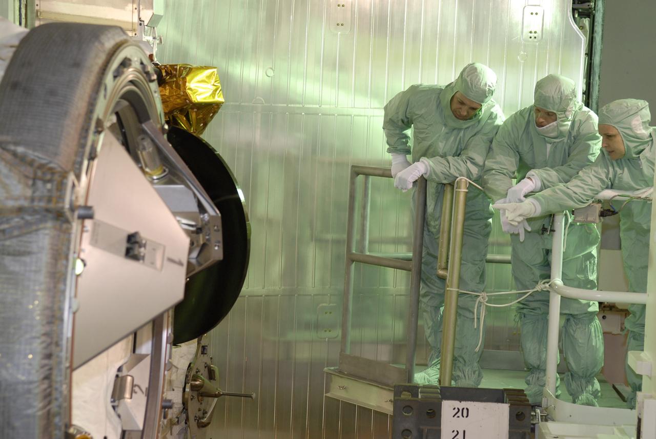 CAPE CANAVERAL, Fla. – On Launch Pad 39A at NASA's Kennedy Space Center in Florida, STS-119 crew members get a close look at the docking adapter installed in space shuttle Discovery's payload bay. At left is Mission Specialist Richard Arnold and at center is Mission Specialist Joseph Acaba. The astronauts are at Kennedy to prepare for launch through Terminal Countdown Demonstration Test activities. The TCDT includes equipment familiarization and a simulated launch countdown. Discovery is targeted to launch on the STS-119 mission Feb. 12. During Discovery's 14-day mission, the crew will install the S6 truss segment and solar arrays to the starboard side of the International Space Station, completing the station's truss, or backbone. Photo credit: NASA/Kim Shiflett